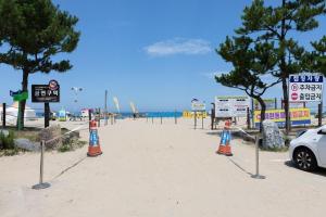 a beach with traffic cones and signs in the sand at Olive Beach Pension in Yangyang