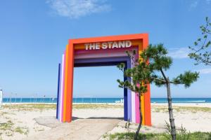 Un puesto colorido en una playa con arena. en Olive Beach Pension, en Yangyang