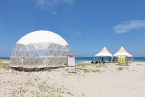 una carpa en la playa con tiendas de campaña en la arena en Olive Beach Pension, en Yangyang 8 fotos más