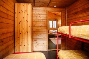 a room with two bunk beds in a log cabin at Knus houten huisje met uitzicht Meer Zeeland VP071 in Heinkensand +45 photos