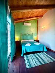 a bedroom with a bed with a blue blanket at Agriturismo Corte Sakura in Montefiascone +52 photos