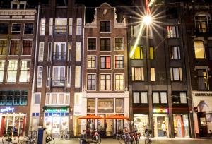 un grupo de edificios en una ciudad por la noche en Hotel The Exchange, en Ámsterdam