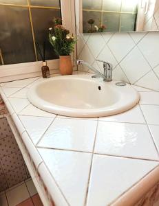 a bathroom sink with a white tiled counter at Julian byb in Cassano Spinola