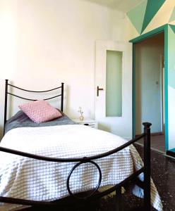 a bedroom with a bed with a pink pillow and a mirror at Julian byb in Cassano Spinola