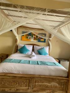 a bedroom with a canopy bed with blue and white pillows at Makna Homestay and Spa in Sidemen +81 photos