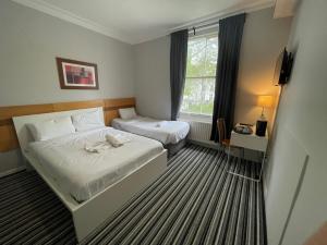 Una habitación de hotel con dos camas y una ventana. en The Chapter Hotels - Princes Square, en Londres