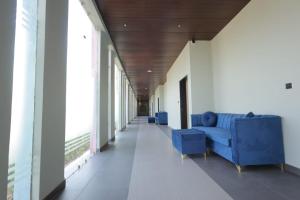 a hallway with a blue couch in a building at Hotel Black Harbour - A Unit of Om Shanti Inn in Bharatpur +18 photos