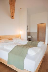 a bedroom with a large white bed with white pillows at Gut Herzogberg in Sonntagberg +24 photos
