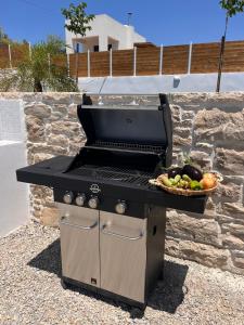 a barbecue grill with a basket of fruit on it at Villa Livia- panoramic view with pool and beautiful garden in Pitsidia