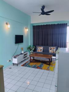 a living room with a couch and a tv at Oceanwhite Homestay Corus in Port Dickson
