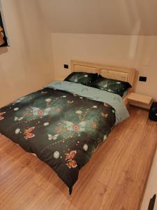 a bedroom with a bed with a black comforter at Cabana Doi Brazi A-FRAME in Dămuc +19 photos