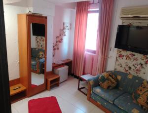 a living room with a couch and a mirror at Samaya in Eforie Nord