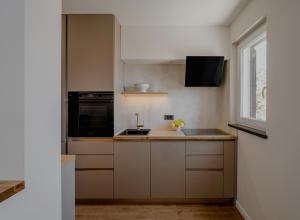 a kitchen with white cabinets and a sink and a window at Labin Home in Labin