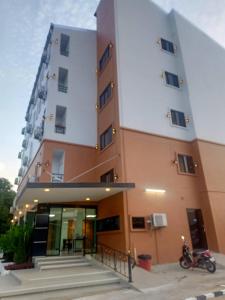 een gebouw met een motorfiets ervoor geparkeerd bij Wish Resident Ubonratchathani in Ban Nong Bua