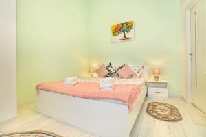 a small bedroom with a bed with pink sheets at Arctic Studio in Braşov