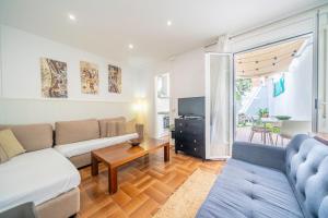 a living room with a couch and a tv at HomeHolidaysRentals Arlene in Calella