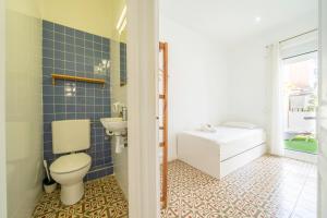 a bathroom with a toilet and a sink and a tub at HomeHolidaysRentals Arlene in Calella +43 photos