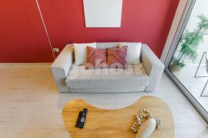 Una sala de estar con un sofá y un control remoto. en Bold Apartment 10 Min From Shopping Mcal Lopez, en Asunción