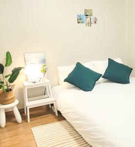 a white couch with blue pillows in a living room at Street to Wave in Busan