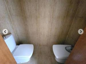 ein Badezimmer mit einer weißen Toilette und einem Waschbecken in der Unterkunft Vera Armony Natura FKK in Playas de Vera + 2 Fotos