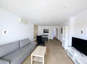 ein Wohnzimmer mit Sofa und Tisch in der Unterkunft Vera Armony Natura FKK in Playas de Vera