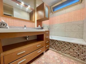 een badkamer met een wastafel, een bad en een spiegel bij Tour Eiffel Francois Gerard in Parijs +13 foto's