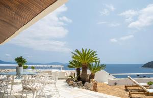a patio with a table and chairs and the ocean at Villa Artisti Marathon in Marathón +74 photos