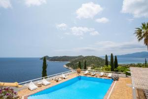 a villa with a swimming pool and a view of the ocean at Villa Artisti Marathon in Marathón