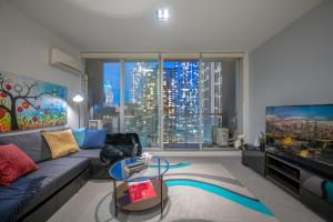 ein Wohnzimmer mit Couch und großem Fenster in der Unterkunft Convenient CBD Retreat in the Best Location in Melbourne