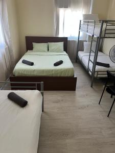 two beds in a room with two bunk beds at Come Inn Costa da Caparica in Costa da Caparica