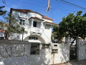 a white house behind a wall with graffiti at Come Inn Costa da Caparica in Costa da Caparica
