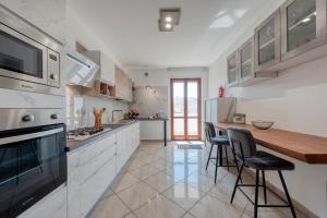 Una cocina con gabinetes blancos y una encimera de madera. en Dimora Green, en Lecce