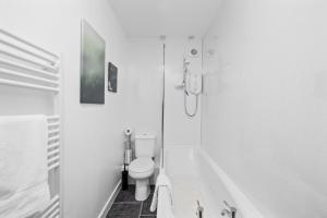 a white bathroom with a toilet and a shower at Steeple View Apartment - Cosy 1 bed in Montrose in Montrose