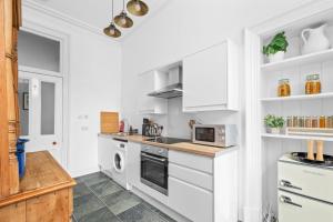 a kitchen with white cabinets and a microwave at Steeple View Apartment - Cosy 1 bed in Montrose in Montrose