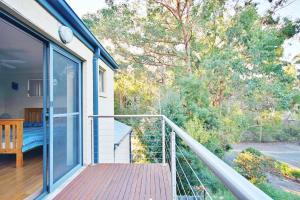 a balcony of a house with a wooden deck at Sand Water at Hyams Beach in Hyams Beach