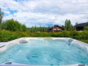 - un grand bain à remous dans une cour avec une maison dans l'établissement Villa Lumikki 1 - 8 henkilölle, Luoteis-Himos Ski-inout, à Jämsä
