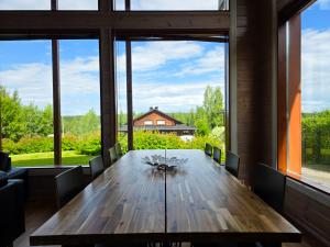 une grande salle à manger avec une table en bois et de grandes fenêtres dans l'établissement Villa Lumikki 1 - 8 henkilölle, Luoteis-Himos Ski-inout, à Jämsä