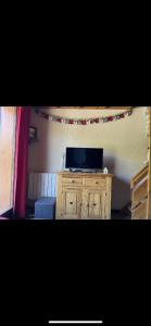 a living room with a tv on a wooden cabinet at Duplex les 2 Alpes in Les Deux Alpes