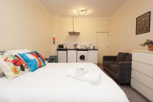 a bedroom with a white bed and a couch at Chic Bath Flat for Couples with Free Parking! in Bath