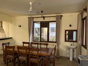 a dining room with a table and chairs and a sink at Almond 7 in Gazi