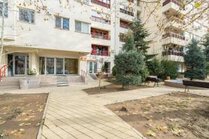 an apartment building with a courtyard with a bench at Green Heaven Apartment 2106 in Bucharest