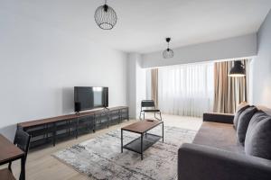 a living room with a couch and a flat screen tv at Green Heaven Apartment 2106 in Bucharest