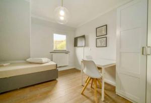 ein kleines Schlafzimmer mit einem Bett und einem Schreibtisch in der Unterkunft Room for one person in a shared apartment in Sylt