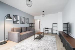 a living room with a couch and a table at Green Heaven Apartment 2106 - Underground Parking & Self Check-in in Bucharest