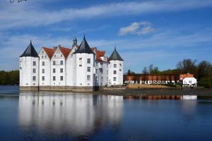 a large white castle sitting on top of a body of water at FeWo Seelücke in Munkbrarup