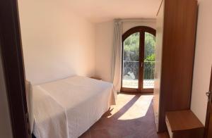 a bedroom with a white bed and a window at Le Palme Big Luxury Costa Smeralda in Arzachena