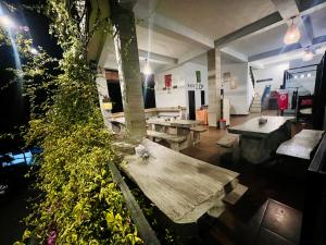 a room with benches and tables and a plant at Hostel KARMA by SEAOM Villas in Ubud