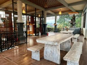 a large wooden table in a building with benches at Hostel KARMA by SEAOM Villas in Ubud