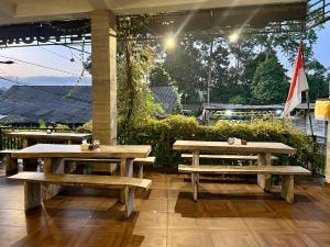 two picnic tables and a flag on a patio at Hostel KARMA by SEAOM Villas in Ubud