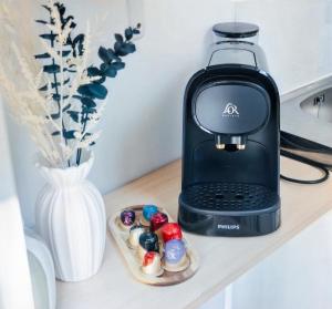 a black blender sitting on a counter next to a vase at Le petit coin vert de Paris in Montreuil